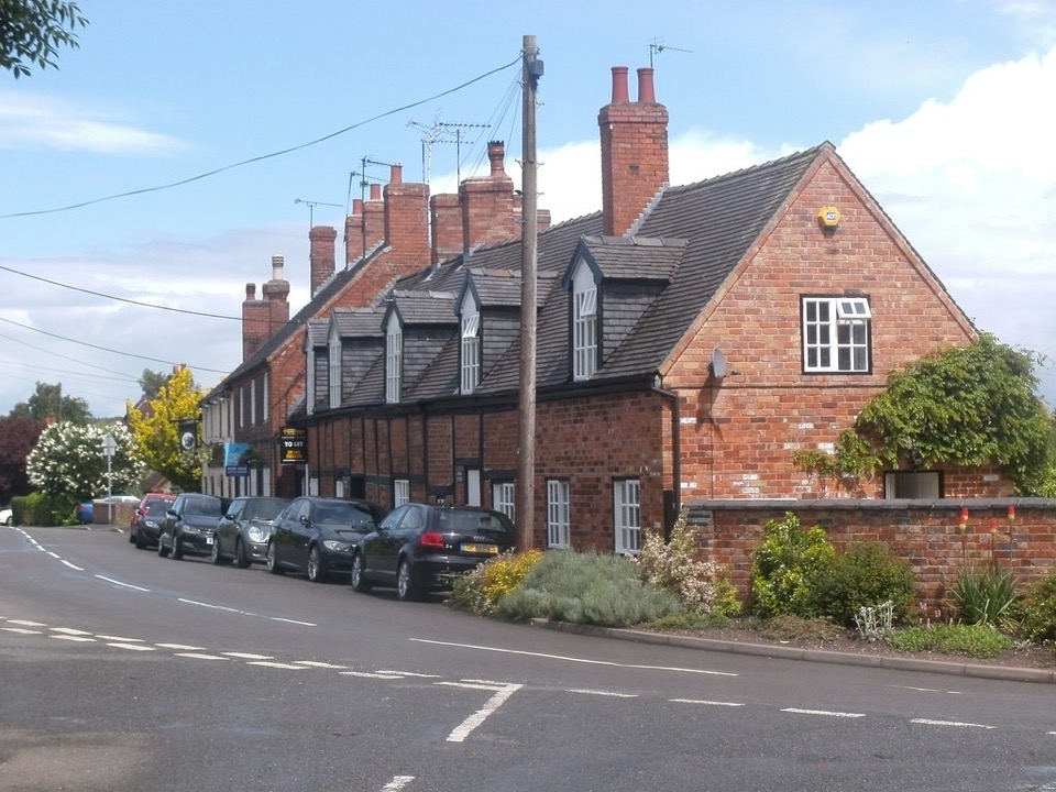 A row of red brick cottages with dormer windows on the main street at Wilson in Leicestershire